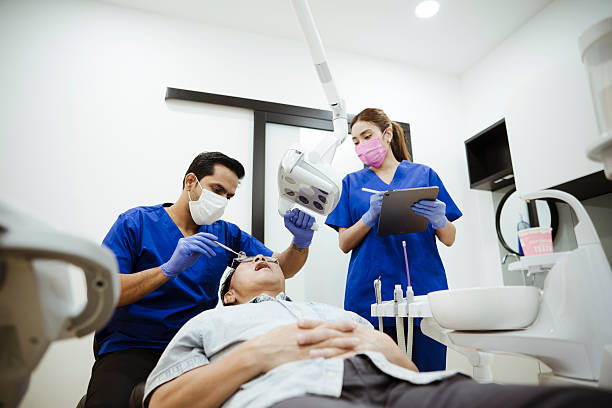 A calm and focused dental team conducts a routine dental exam. The dentist uses precise instruments while the assistant supports the procedure, reflecting best practices in preventive oral care.